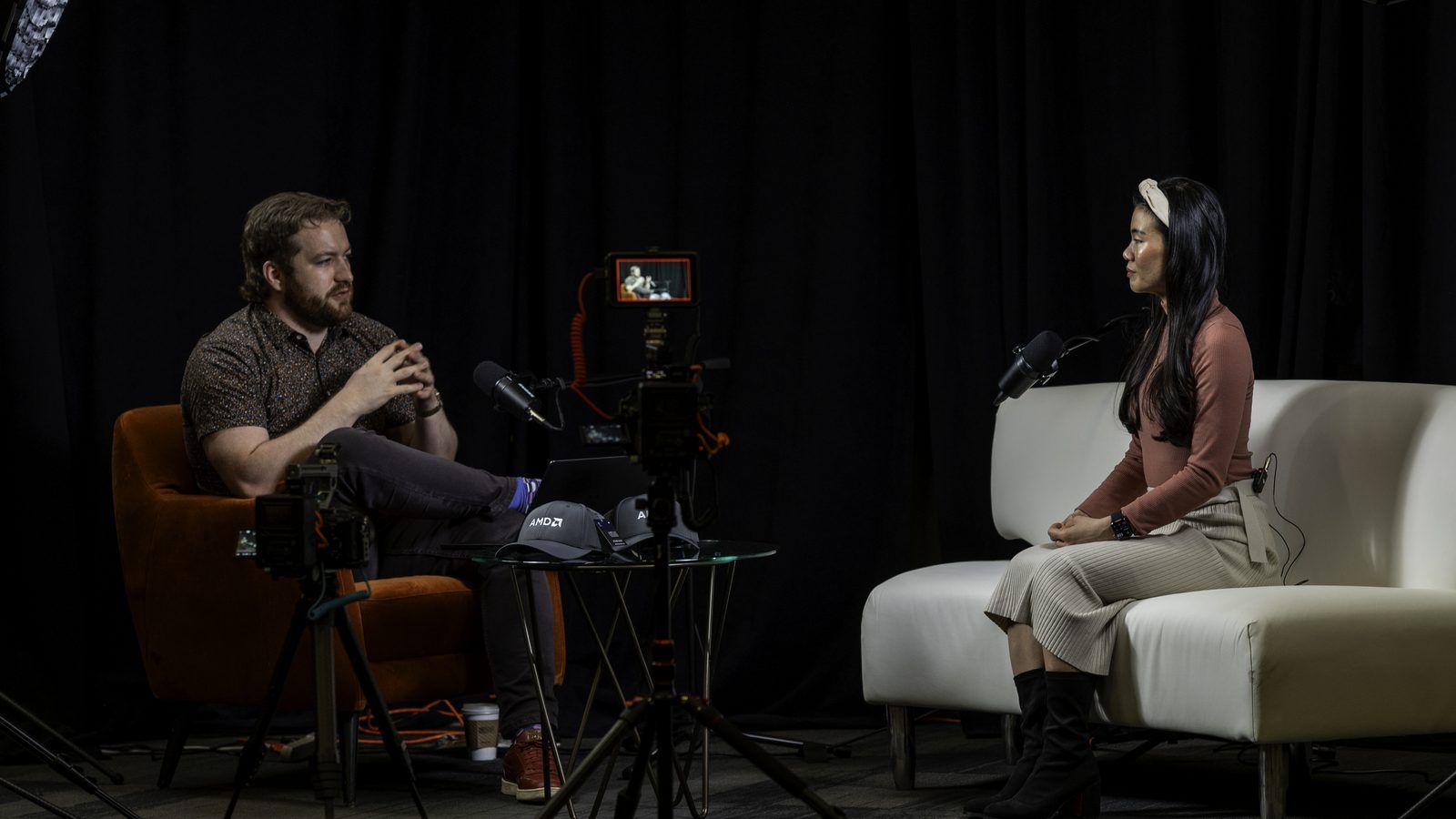 Conor Bronsdon in conversation with a guest on the Chain of Thought set — two chairs, studio lighting, and a camera rig between them